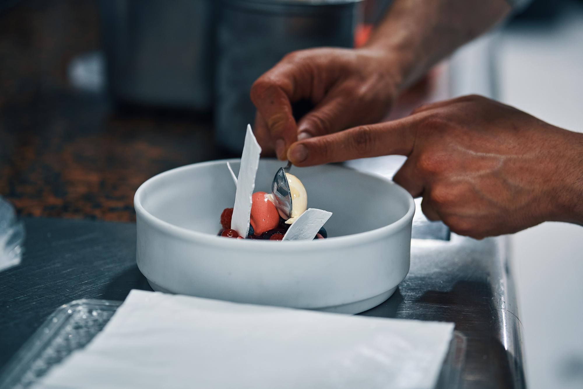 Instructor demonstrating plating technique in a calm kitchen